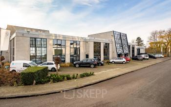 Modern office space rental at Voorerf 2-20 in Breda Noord-West with parked cars and clean architectural design.